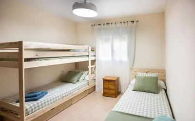 a bedroom with two bunk beds and a window at Hogar Lowill in Chiclana de la Frontera
