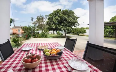 a table with a bowl of fruit on a checkered table cloth at Hogar Lowill in Chiclana de la Frontera