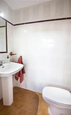 a bathroom with a white toilet and a sink at Hogar Lowill in Chiclana de la Frontera