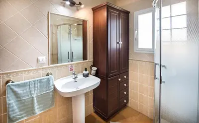 a bathroom with a sink and a mirror and a shower at Hogar Lowill in Chiclana de la Frontera