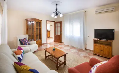 a living room with a couch and a tv at Hogar Lowill in Chiclana de la Frontera
