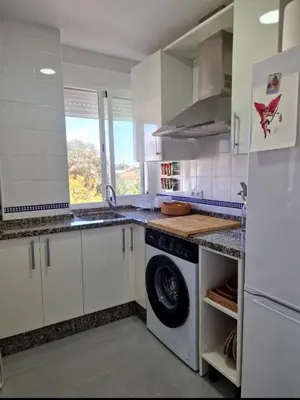 a white kitchen with a washing machine in it at Irina playa 6 luminoso, piscina, aire y parking in Sanlúcar de Barrameda