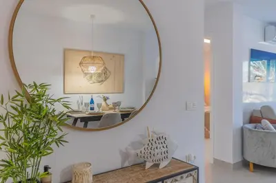 a living room with a large mirror on the wall at Coqueto apartamento en primera linea de playa in Novo Sancti Petri
