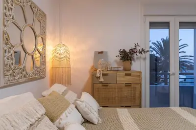 a bedroom with a bed and a dresser with a window at Coqueto apartamento en primera linea de playa in Novo Sancti Petri