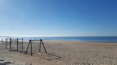 an empty swing set on a sandy beach at Coqueto apartamento en primera linea de playa in Novo Sancti Petri