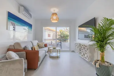 a living room with a couch and a plant at Coqueto apartamento en primera linea de playa in Novo Sancti Petri