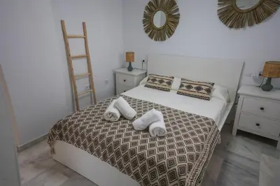 a bedroom with a bed with towels on it at Charming Apartment with Private Terrace in Sanlúcar de Barrameda