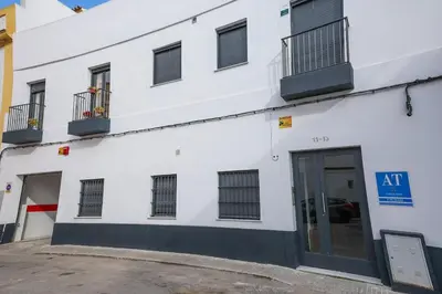 a white building with a door and windows at Charming Apartment with Private Terrace in Sanlúcar de Barrameda