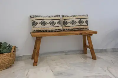 two pillows sitting on a wooden bench against a wall at Charming Apartment with Private Terrace in Sanlúcar de Barrameda