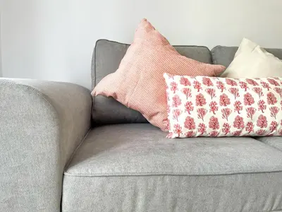 a gray couch with two pillows on it at El Arrecife - Apartamento a 2 minutos de la playa en El Puerto de Santa María in El Puerto de Santa María