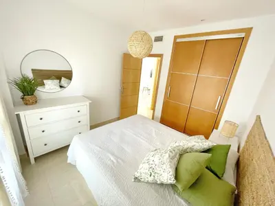 a bedroom with a bed and a dresser and a mirror at El Arrecife - Apartamento a 2 minutos de la playa en El Puerto de Santa María in El Puerto de Santa María