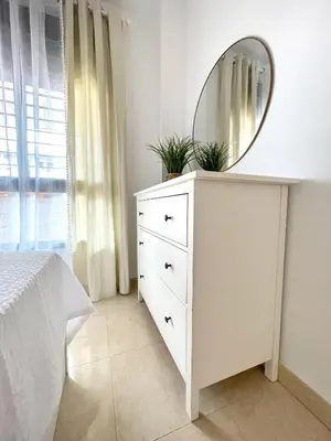 a bedroom with a white dresser with a mirror at El Arrecife - Apartamento a 2 minutos de la playa en El Puerto de Santa María in El Puerto de Santa María