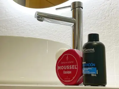 a bottle of cosmetics sitting next to a sink at El Arrecife - Apartamento a 2 minutos de la playa en El Puerto de Santa María in El Puerto de Santa María