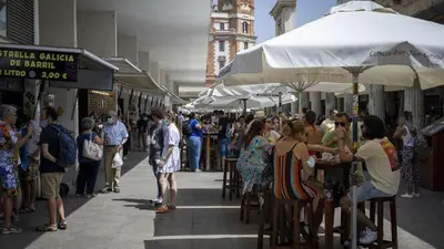 a crowd of people standing on a street with umbrellas at La Casita de Cai in Cádiz