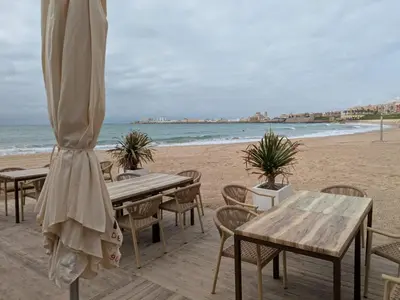 a group of tables and chairs on the beach at La Casita de Cai in Cádiz