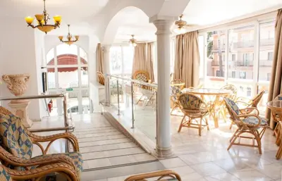 a living room with a table and chairs at HOTEL Guadalupe in Chipiona