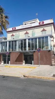 a building on the corner of a street at HOTEL Guadalupe in Chipiona