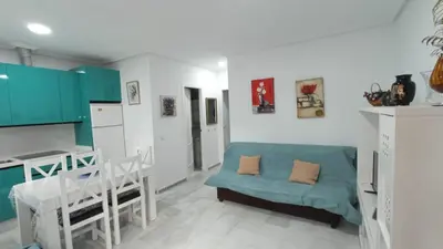 a living room with a couch and a kitchen at Apartamento en La Barrosa, Chiclana de la Frontera in Novo Sancti Petri