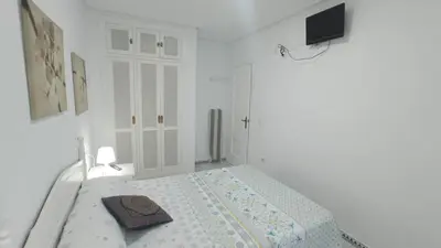 a white room with a bed with a towel on it at Apartamento en La Barrosa, Chiclana de la Frontera in Novo Sancti Petri