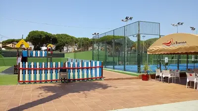 a park with a pool with a fence and an umbrella at Apartamento en La Barrosa, Chiclana de la Frontera in Novo Sancti Petri