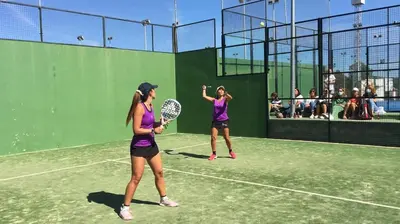 two women playing tennis on a tennis court at Apartamento en La Barrosa, Chiclana de la Frontera in Novo Sancti Petri