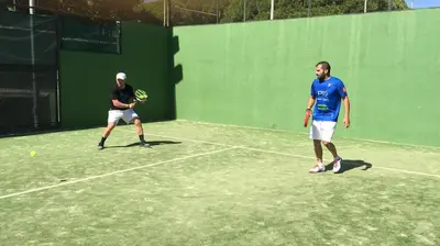 two men playing tennis on a tennis court at Apartamento en La Barrosa, Chiclana de la Frontera in Novo Sancti Petri