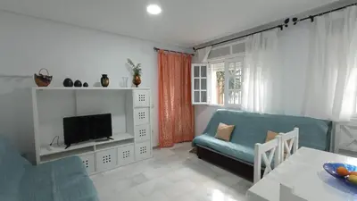 a living room with a blue couch and a tv at Apartamento en La Barrosa, Chiclana de la Frontera in Novo Sancti Petri
