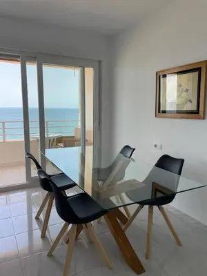 a glass dining room table with two black chairs at Paseo Marítimo 8 Cádiz in Cádiz