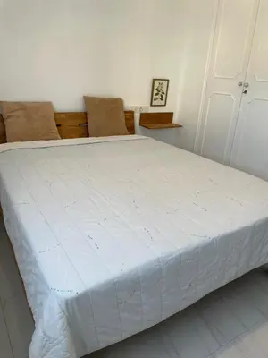 a large white bed in a room with two chairs at Paseo Marítimo 8 Cádiz in Cádiz
