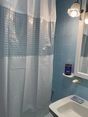 a bathroom with a shower curtain and a sink at Paseo Marítimo 8 Cádiz in Cádiz