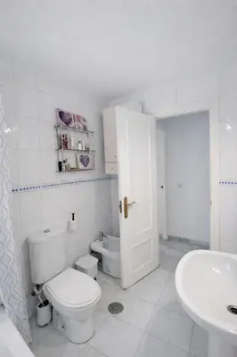 a white bathroom with a toilet and a sink at Apartamento 3 dormitorios con garaje y wifi gratis a pocos minutos del centro de Jerez in Jerez de la Frontera