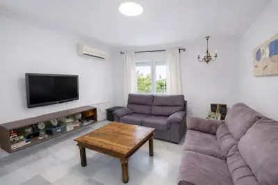 a living room with a couch and a table at Apartamento 3 dormitorios con garaje y wifi gratis a pocos minutos del centro de Jerez in Jerez de la Frontera