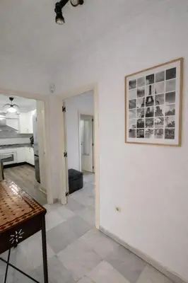 a living room with a table and a picture on the wall at Apartamento 3 dormitorios con garaje y wifi gratis a pocos minutos del centro de Jerez in Jerez de la Frontera