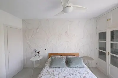 a bedroom with a bed and a white wall at Apartamento 3 dormitorios con garaje y wifi gratis a pocos minutos del centro de Jerez in Jerez de la Frontera