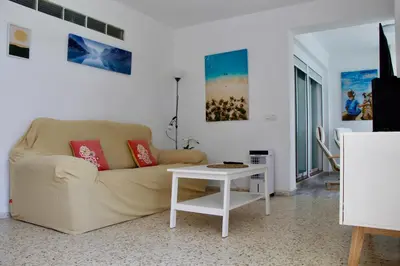 a bedroom with a bed and a picture on the wall at Feel Beach Apartamento del Mar in El Puerto de Santa María