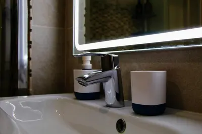 a bathroom sink with a faucet and cups on it at Feel Beach Apartamento del Mar in El Puerto de Santa María