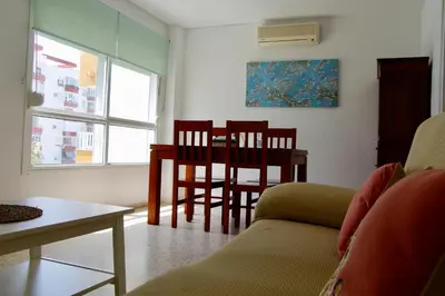 two white chairs and a table in a room at Feel Beach Apartamento del Mar in El Puerto de Santa María