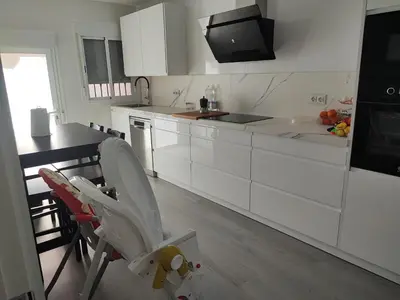 a kitchen with white cabinets and a chair in it at El Refugio de MELKART in San Fernando