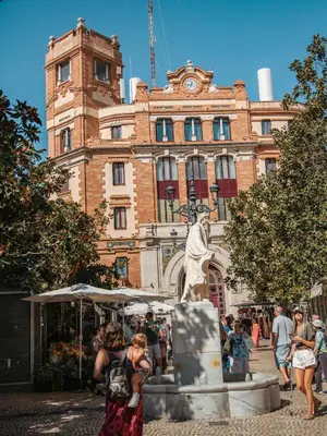a statue in front of a building with a clock tower at Hidden Gem PLAYA DE SANTA MARÍA SUITES by ApartmentsinCadiz in Cádiz