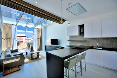 a kitchen and living room with a table and chairs at El Armador Casa Palacio by Luxury Suites Cádiz in Cádiz