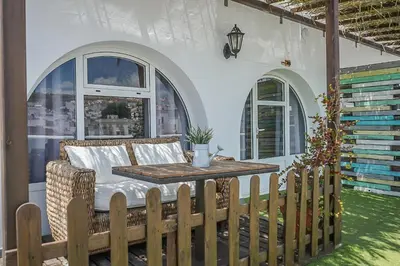 a patio with a table and a couch on a porch at Hotel Posada de las Cuevas in Arcos de la Frontera