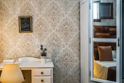 a bedroom with a bed and a desk with a lamp at Hotel Posada de las Cuevas in Arcos de la Frontera
