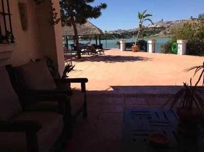 a patio with a couch and a view of the water at Espectacular casa con embarcadero. in Arcos de la Frontera