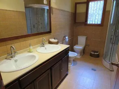 a bathroom with two sinks and a toilet at Espectacular casa con embarcadero. in Arcos de la Frontera