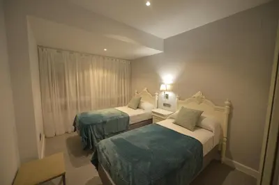 a hotel room with two beds with blue sheets at Apartamento Victoria in Cádiz