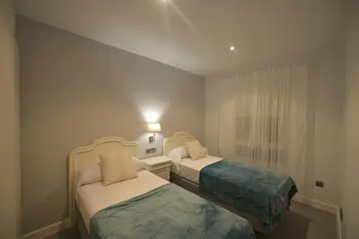 a small room with two beds and a window at Apartamento Victoria in Cádiz