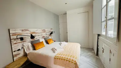 a bedroom with a bed with a wooden headboard at Apartamentos GADIR CENTRO in Cádiz