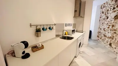 a white kitchen with a sink and a microwave at Apartamentos GADIR CENTRO in Cádiz