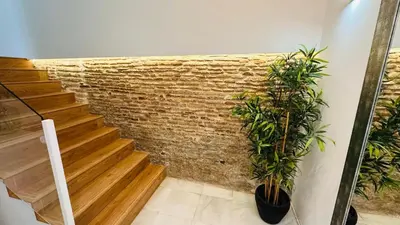 a staircase with a brick wall and two potted plants at Apartamentos GADIR CENTRO in Cádiz