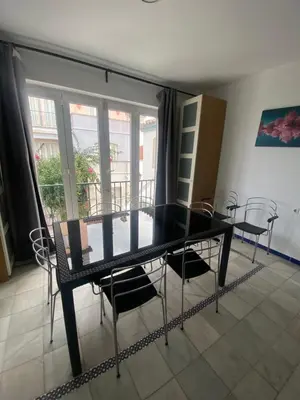 a dining room with a glass table and chairs at Apartamento Medina Puerto Sherry in El Puerto de Santa María
